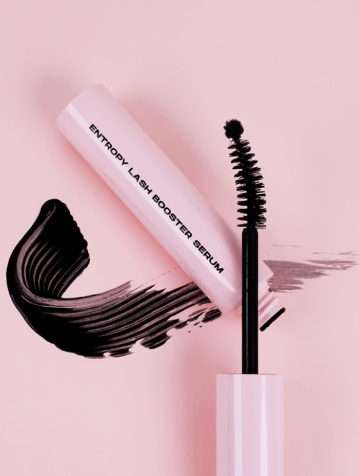 A tube of Entropy Lash Booster Serum with an open brush applicator