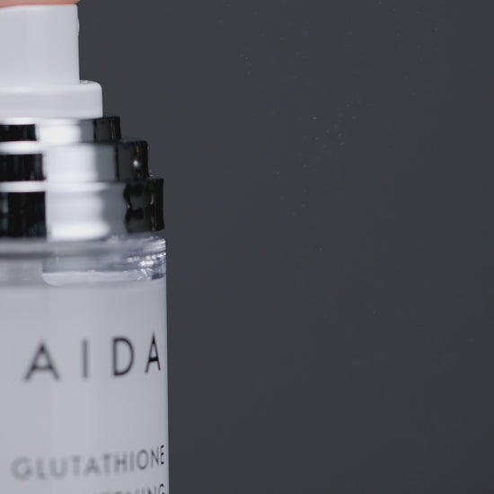 a spray nozzle releasing a fine mist from an AIDA Glutathione Brightening Ampoule Mist bottle, capturing the moment of dispersion to highlight the product's refreshing and hydrating features