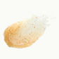 a scoop of fig whiskey body scrub, highlighting the textured consistency and natural exfoliants against a clean background, showcasing the product's organic appeal.