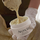 Arencia Fresh Cleanser being scooped out of the jar, showing its thick texture