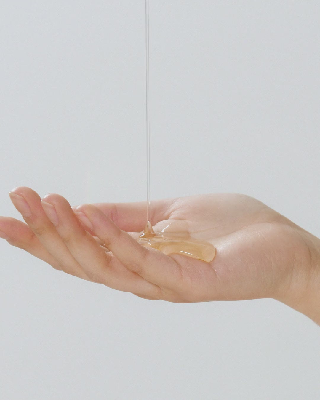 Amber liquid being poured onto a hand