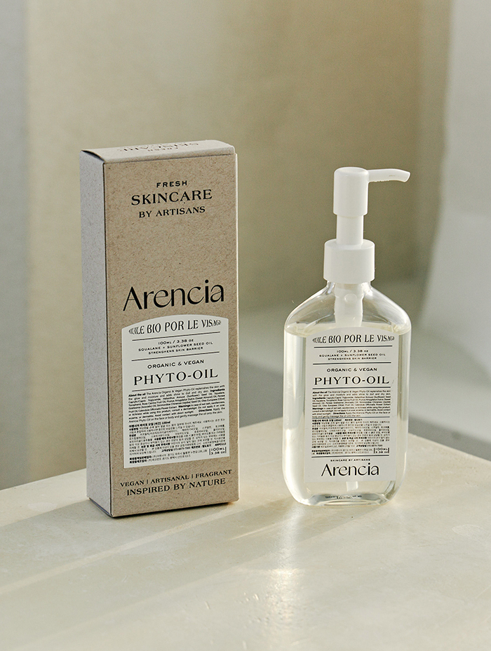 Arencia Phyto-Oil bottle placed next to its eco-friendly packaging, highlighting the product’s vegan and artisanal nature